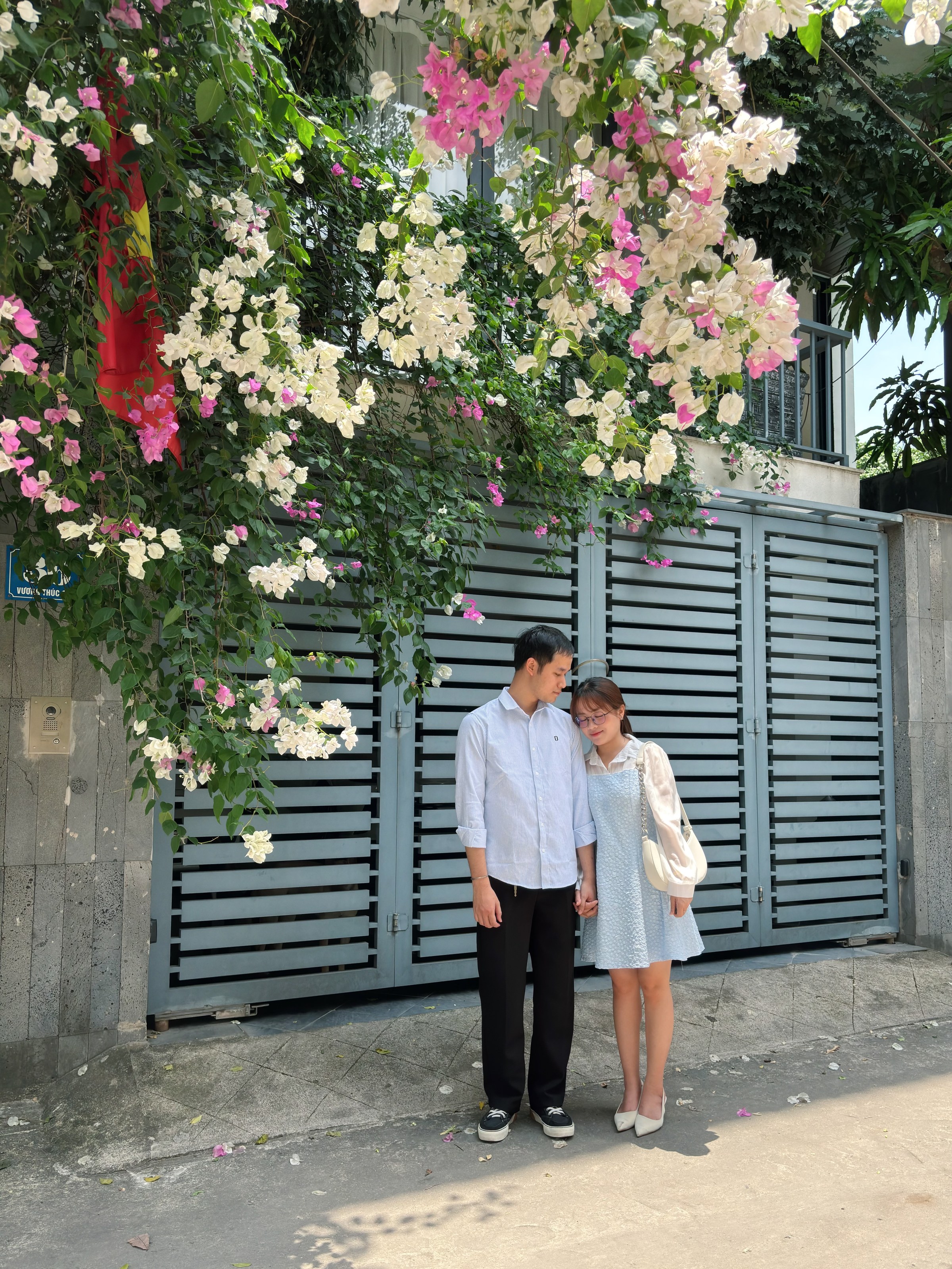 Dung và Tùng đứng bên nhau dưới giàn hoa giấy